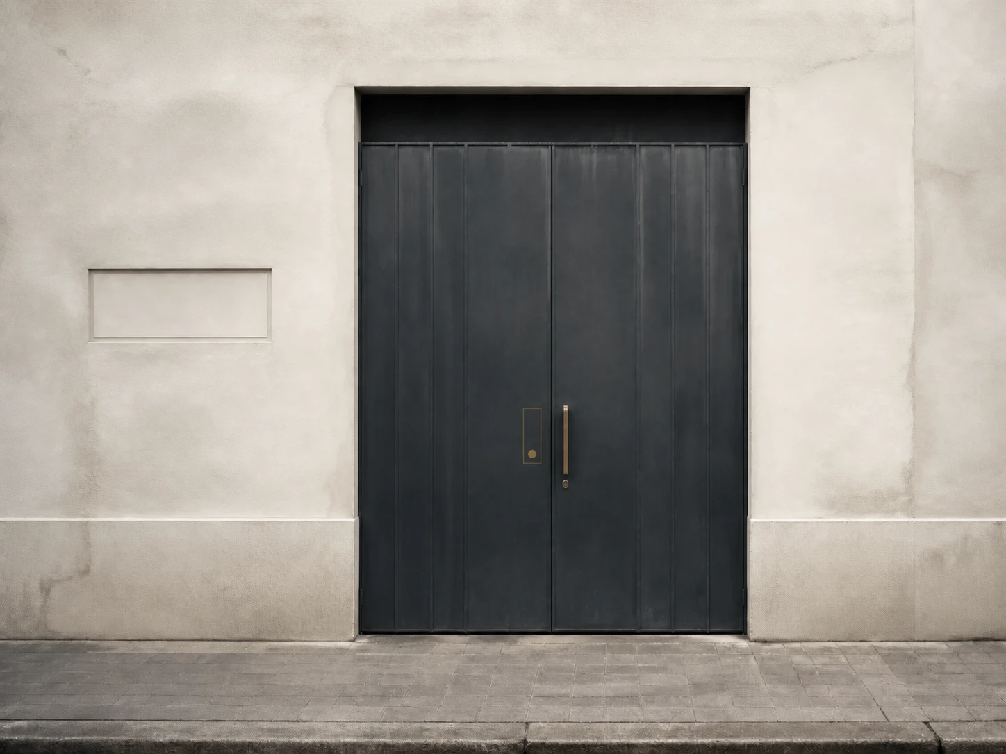 El portón gris de la entrada, sin rótulo a la calle
